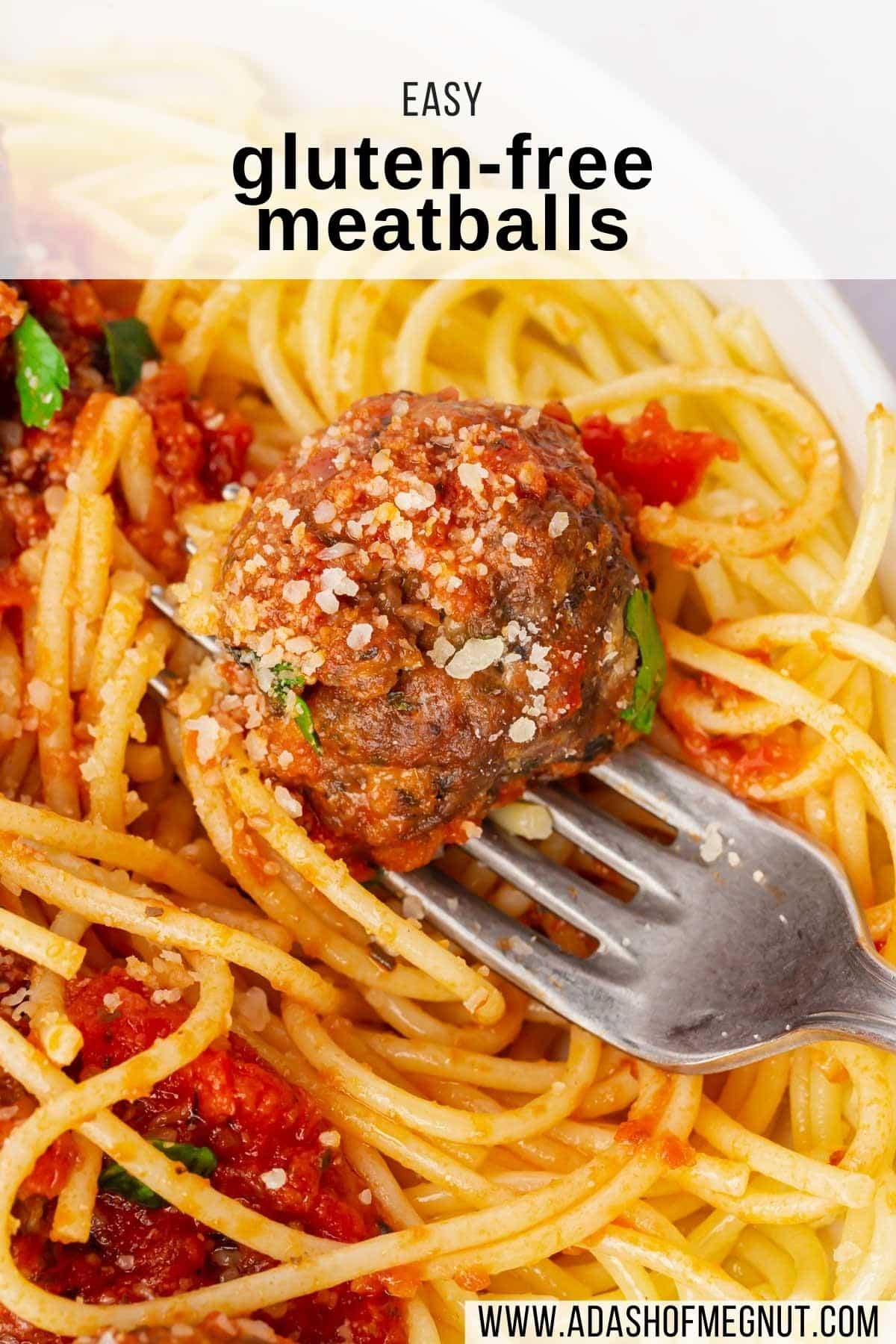 A closeup of a gluten-free beef meatball in a bowl of spaghetti with marinara sauce and a fork.