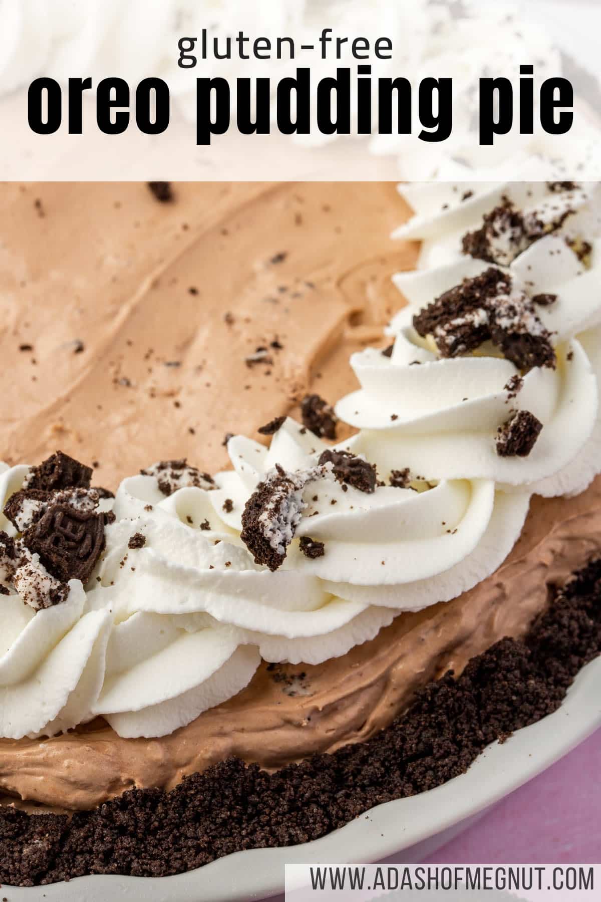 A close up of a gluten-free Oreo pudding pie topped with swirls of whipped cream and crushed Oreos.