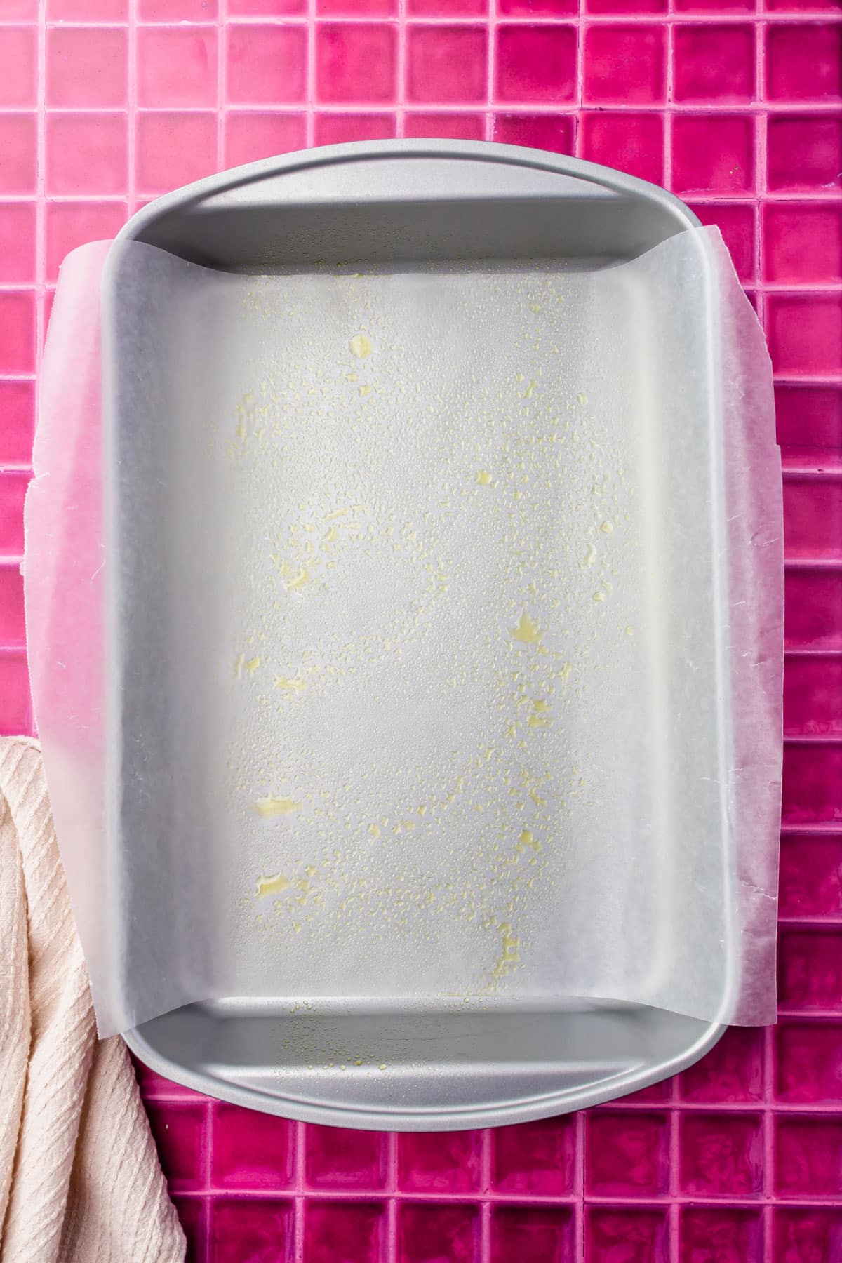 A metal rectangle baking pan that has been lined with wax paper and greased with nonstick cooking spray.