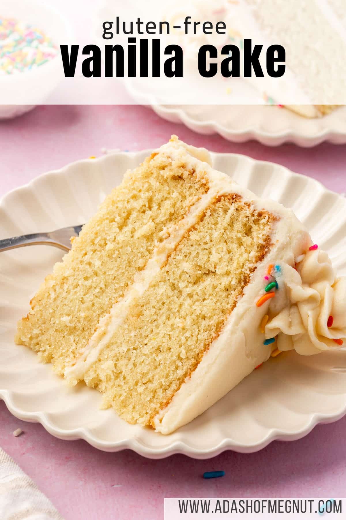 A single slice of gluten free vanilla cake with vanilla frosting and sprinkles on a scalloped white dessert plate.