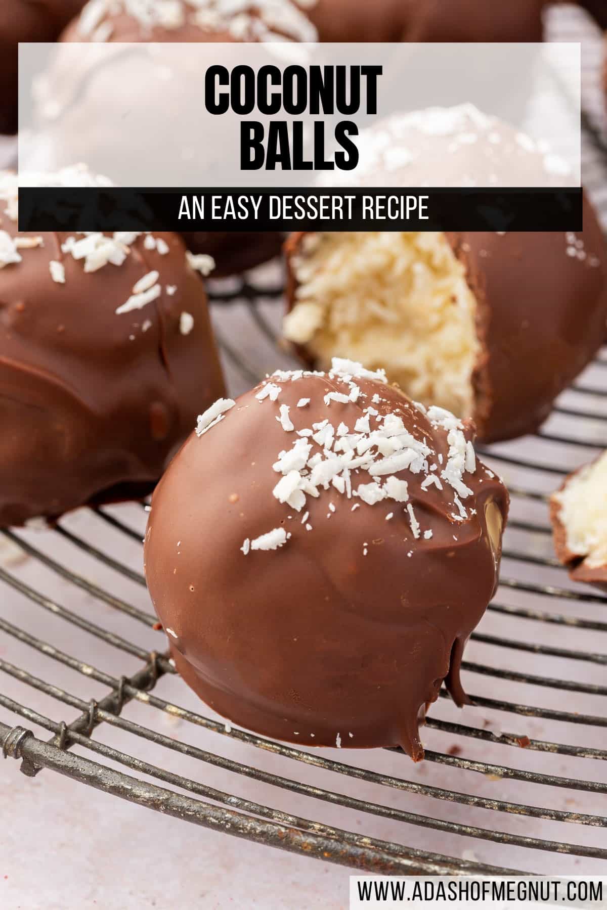 A chocolate covered coconut ball with shredded coconut topping on a wire cooling rack with more truffles in the background.