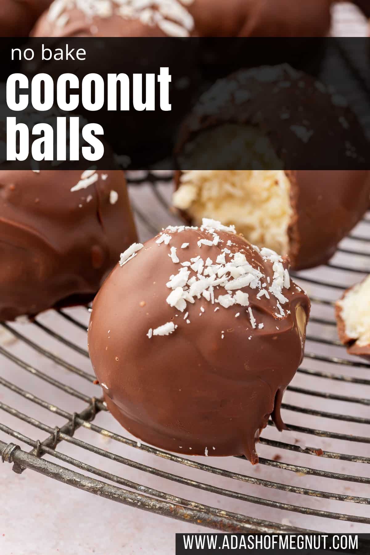 A single chocolate covered coconut ball on a wire cooling rack with more coconut truffles in the background.