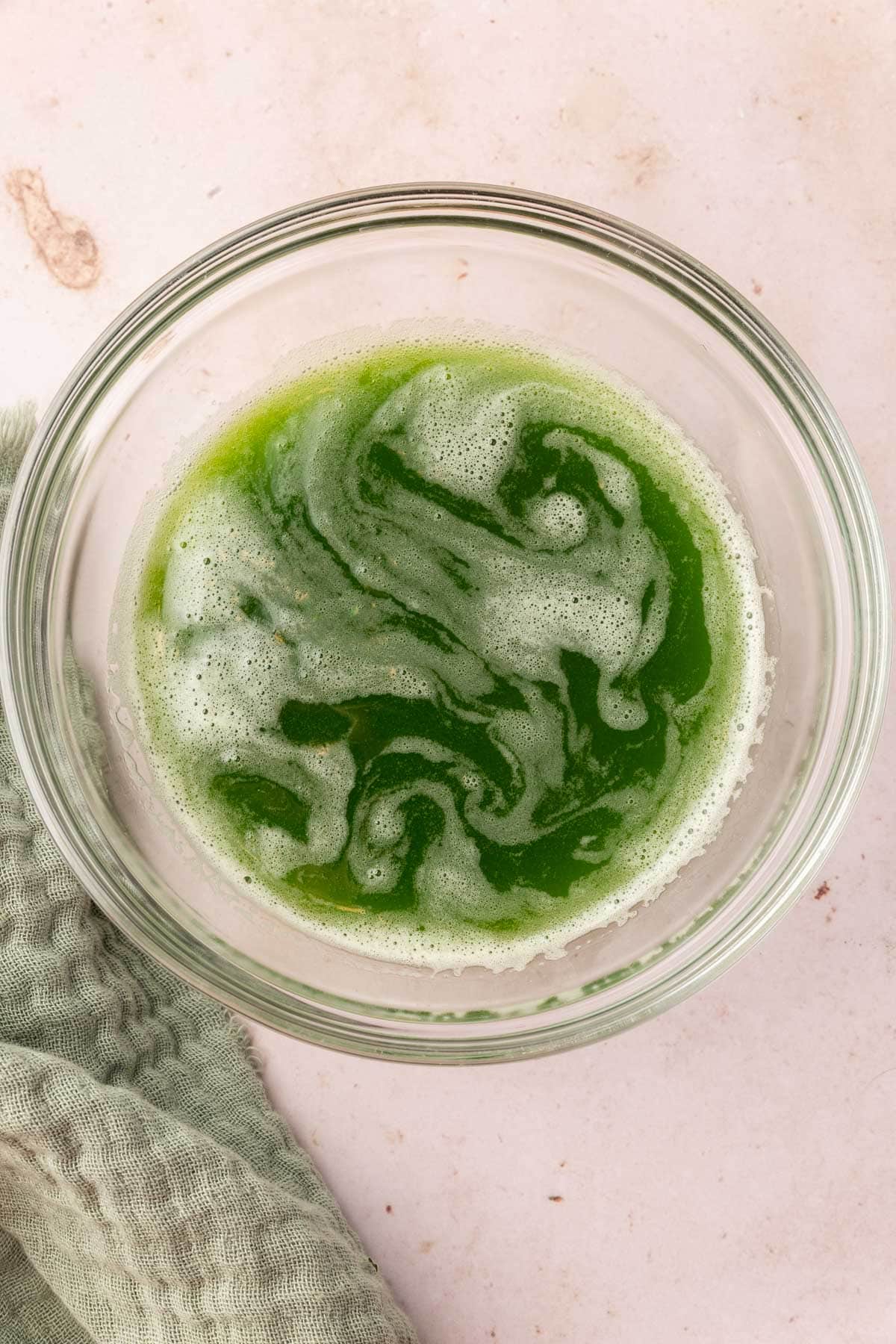 A glass bowl with cucumber juice in it.