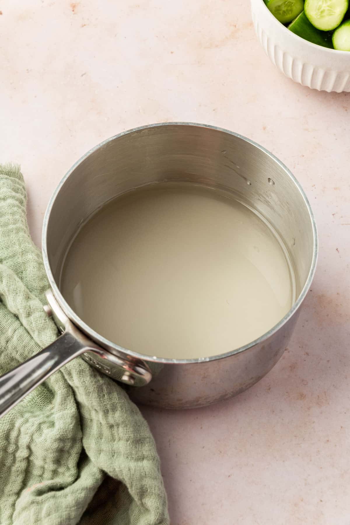 A saucepan with granulated sugar and water in it before boiling into a simple syrup.