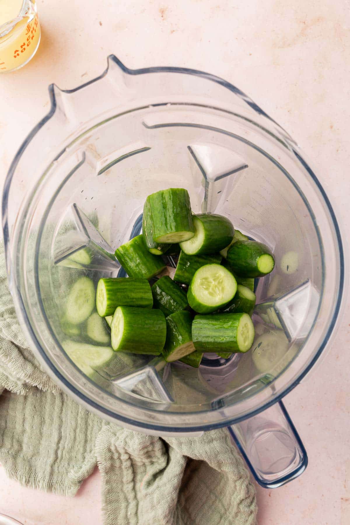 A high-powered blender with chunks of Persian cucumbers in it.