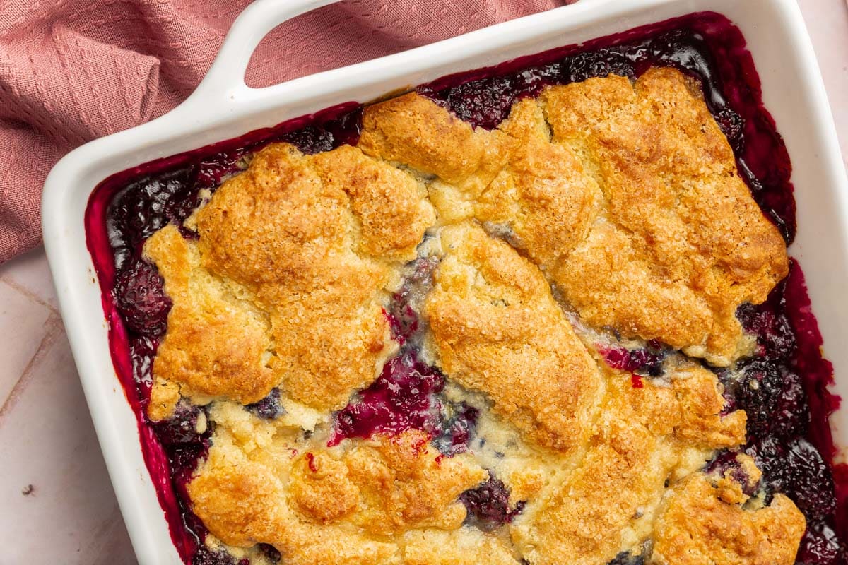 A square baking dish with gluten free blackberry cobbler in it.