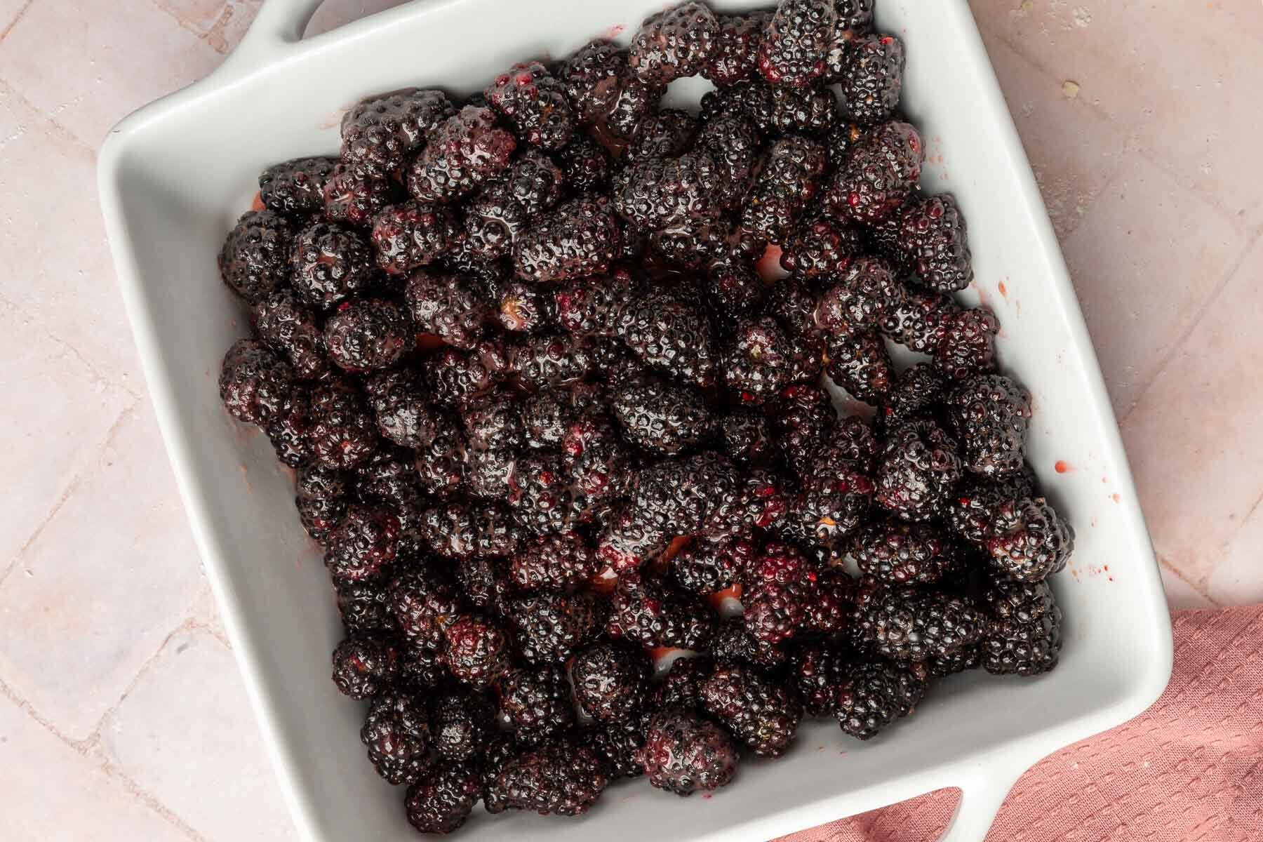 A square baking dish with blackberries mixed with sugar, lemon juice and cornstarch.