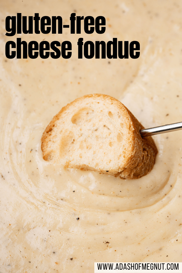 A piece of gluten-free bread that has been skewered with a fondue fork and is being dragged through gluten-free cheese fondue.