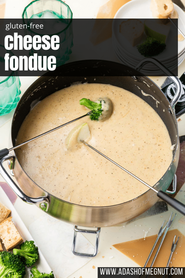 A skewered piece of broccoli and a skewered piece of apple dipped into a fondue pot of gluten-free cheese fondue.