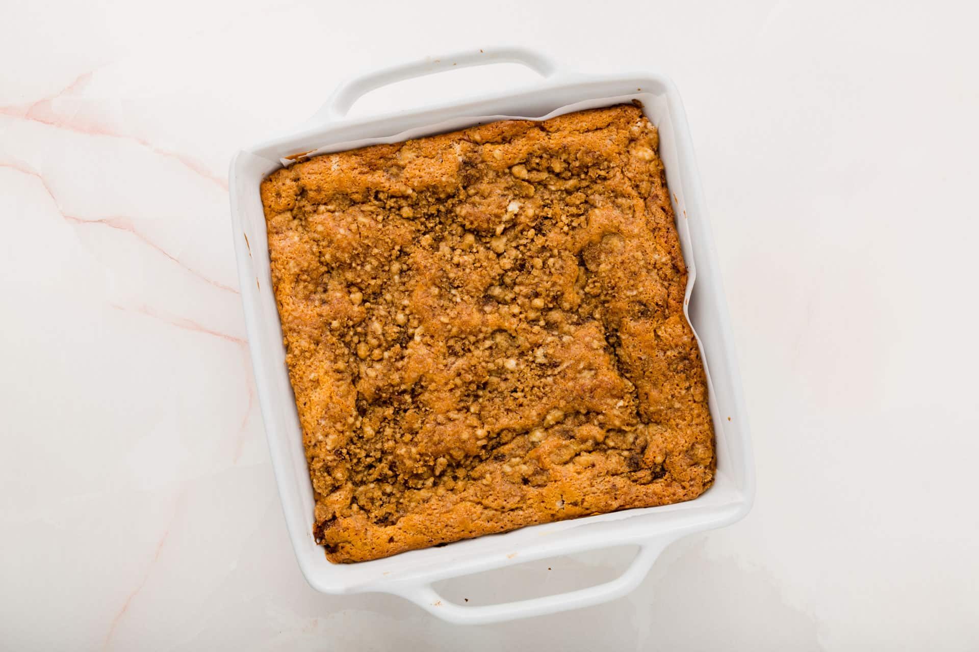 A square baking dish filled with a gluten-free coffee cake with streusel.