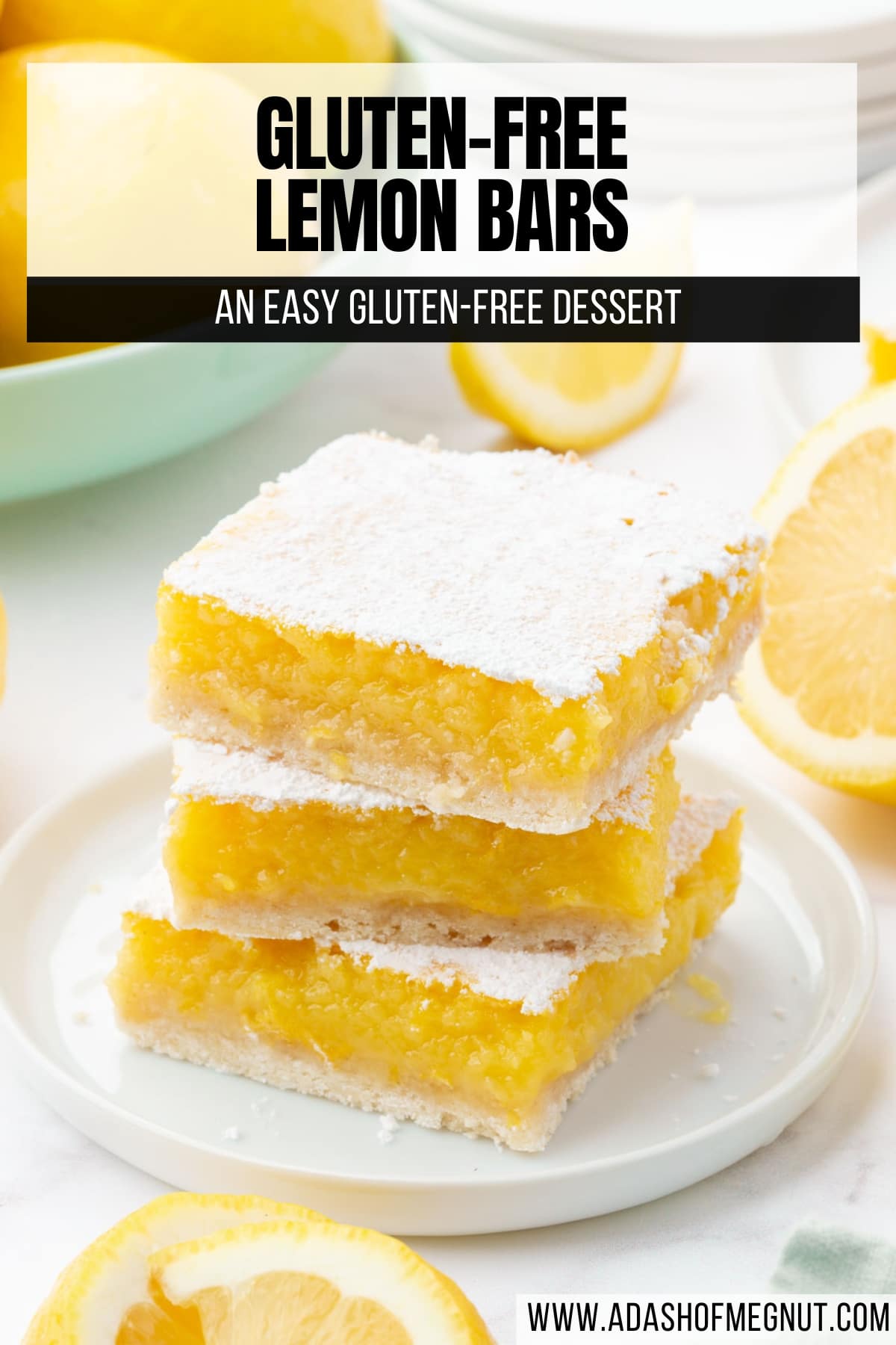 A stack of three gf lemon bars dusted with powdered sugar on a dessert plate with sliced lemons surrounding the plate.