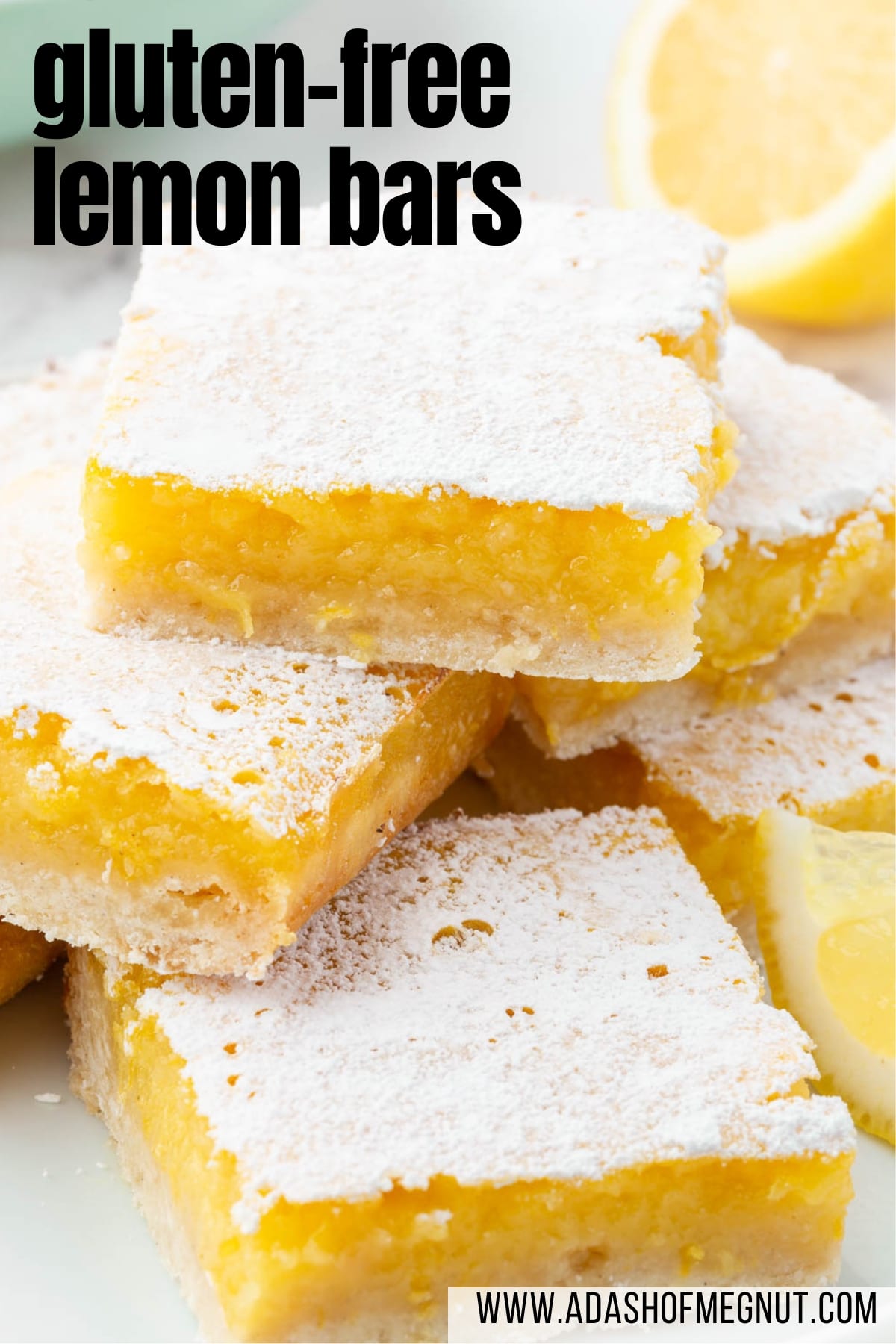 Stacks of gluten free lemon squares on a plate with a lemon half in the background.