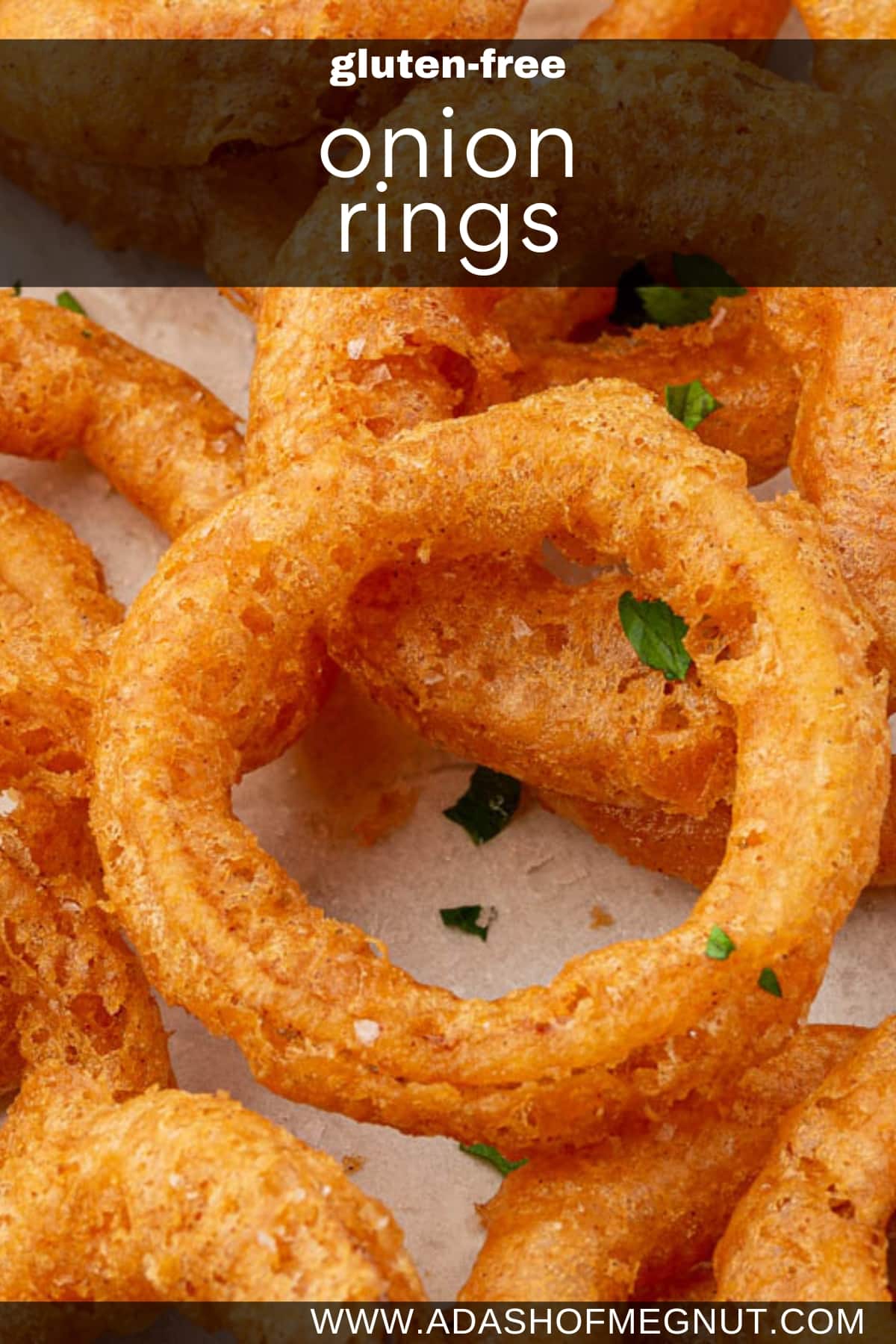 A closeup of a gluten free onion ring topped with fresh parsley and flaky sea salt.