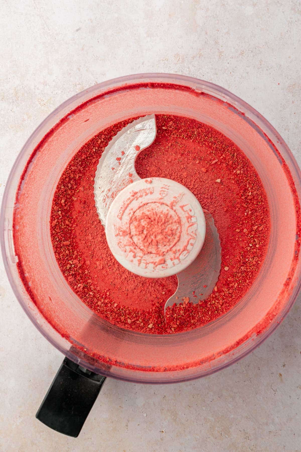 A food processor with freeze-dried strawberry powder in it.