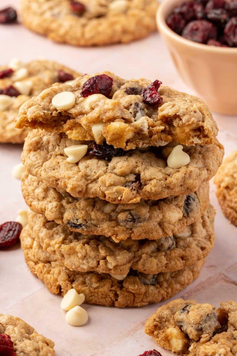 A stack of 5 gluten-free oatmeal cookies with the top one cut in half to see the inside.
