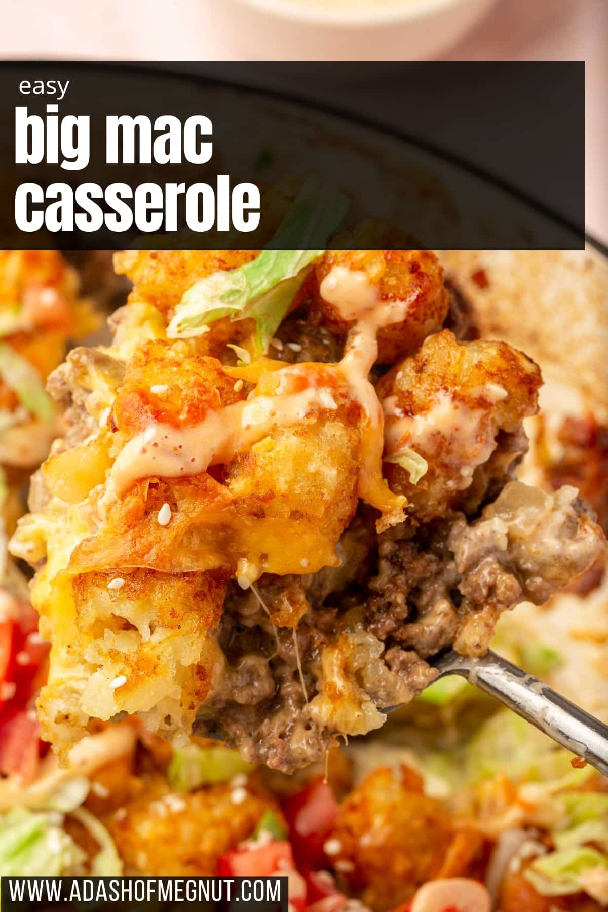 A large serving spoon scooping a portion of big mac tater tot casserole out of a larger braising pan.