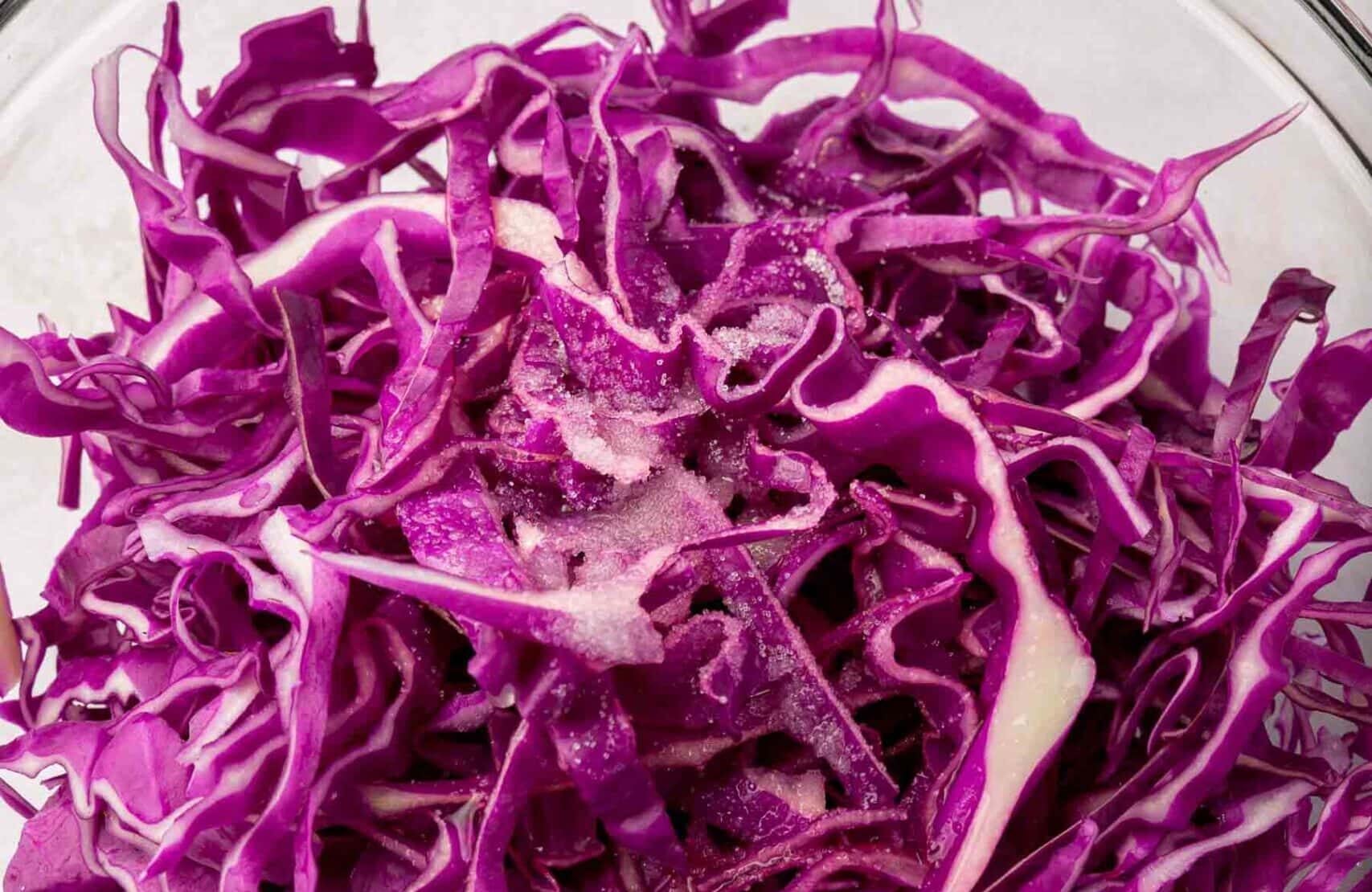 A bowl of red cabbage topped with lime juice, and salt.