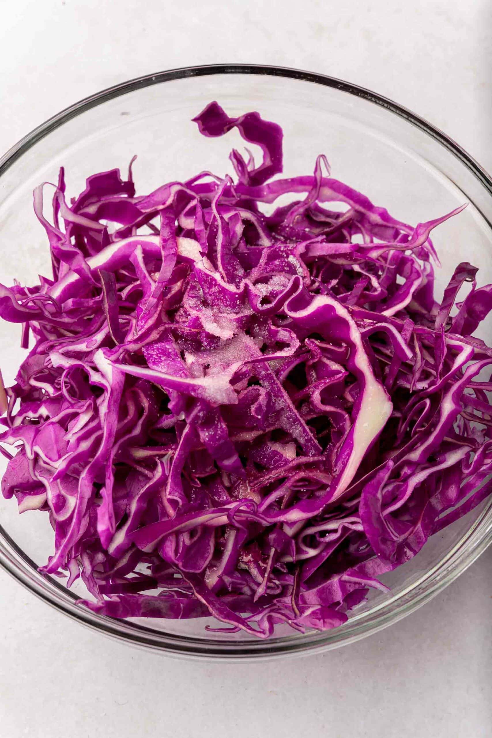 A bowl of red cabbage topped with lime juice, and salt.