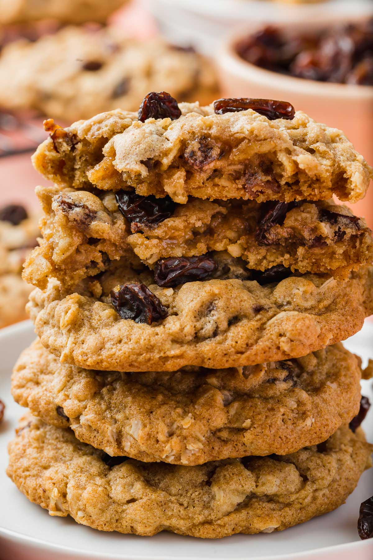 A stack of gluten free oatmeal raisin cookies with the top two being broken in half to see the interior.