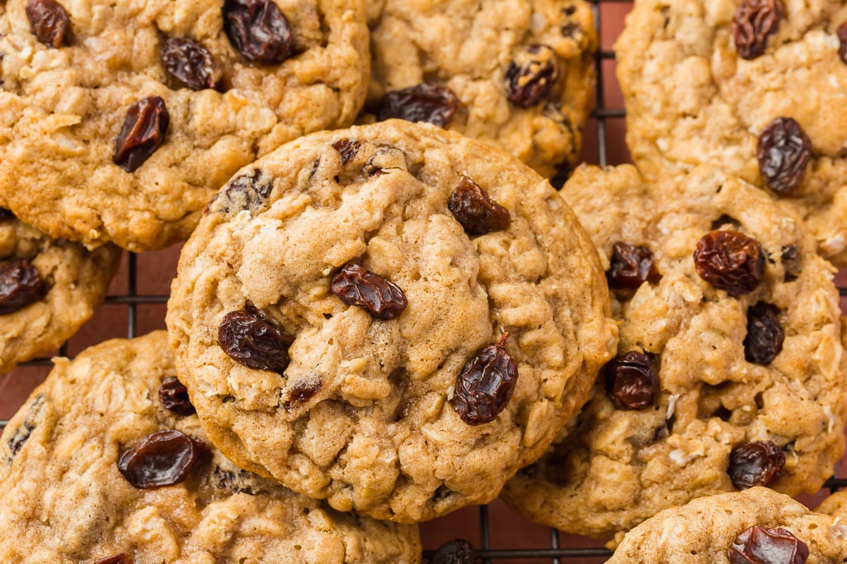 Gluten free oatmeal raisin cookies stacked on top of each other on a wire rack.