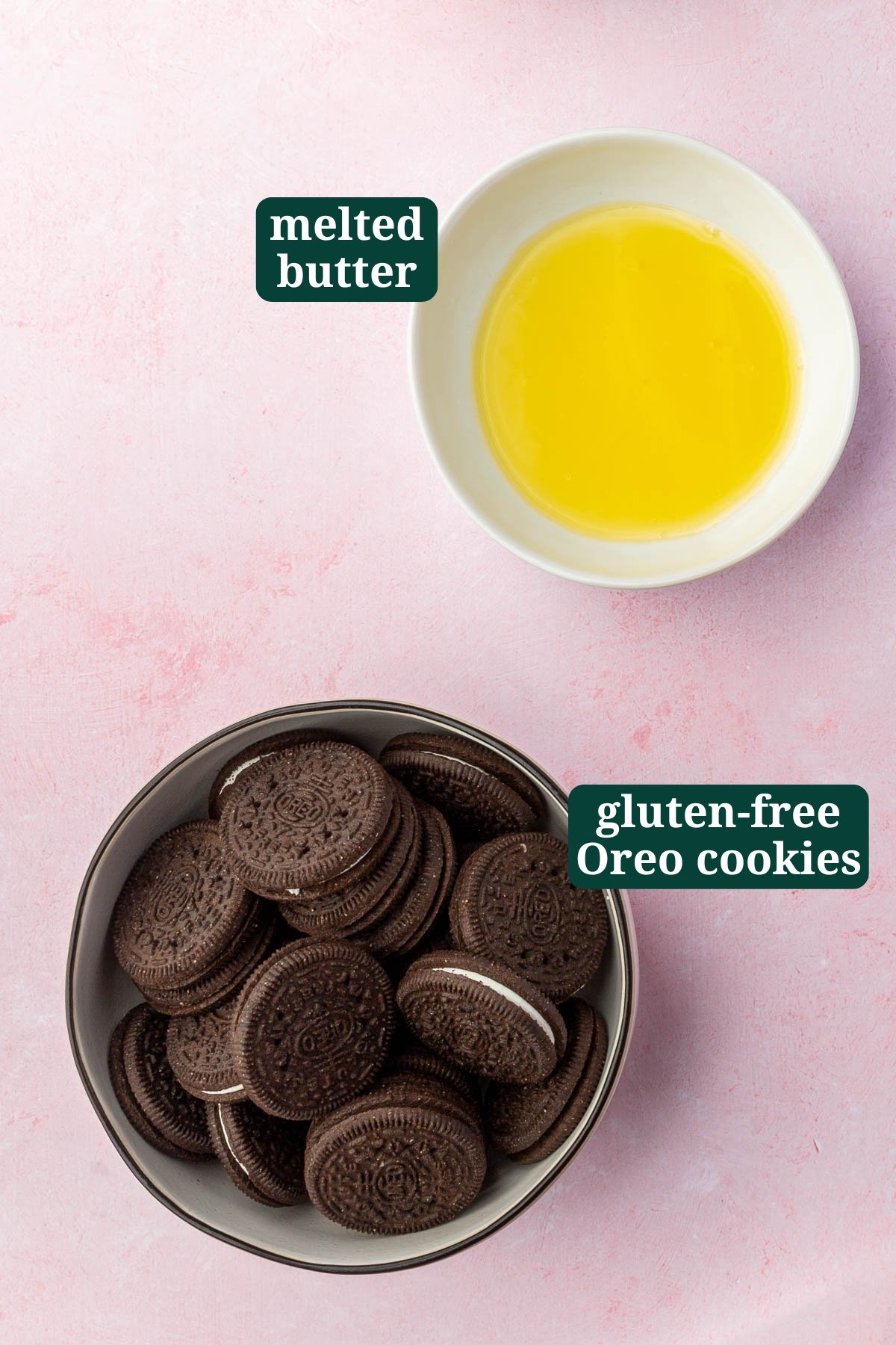 A bowl of gluten-free Oreos and a bowl of melted butter on a pink table.