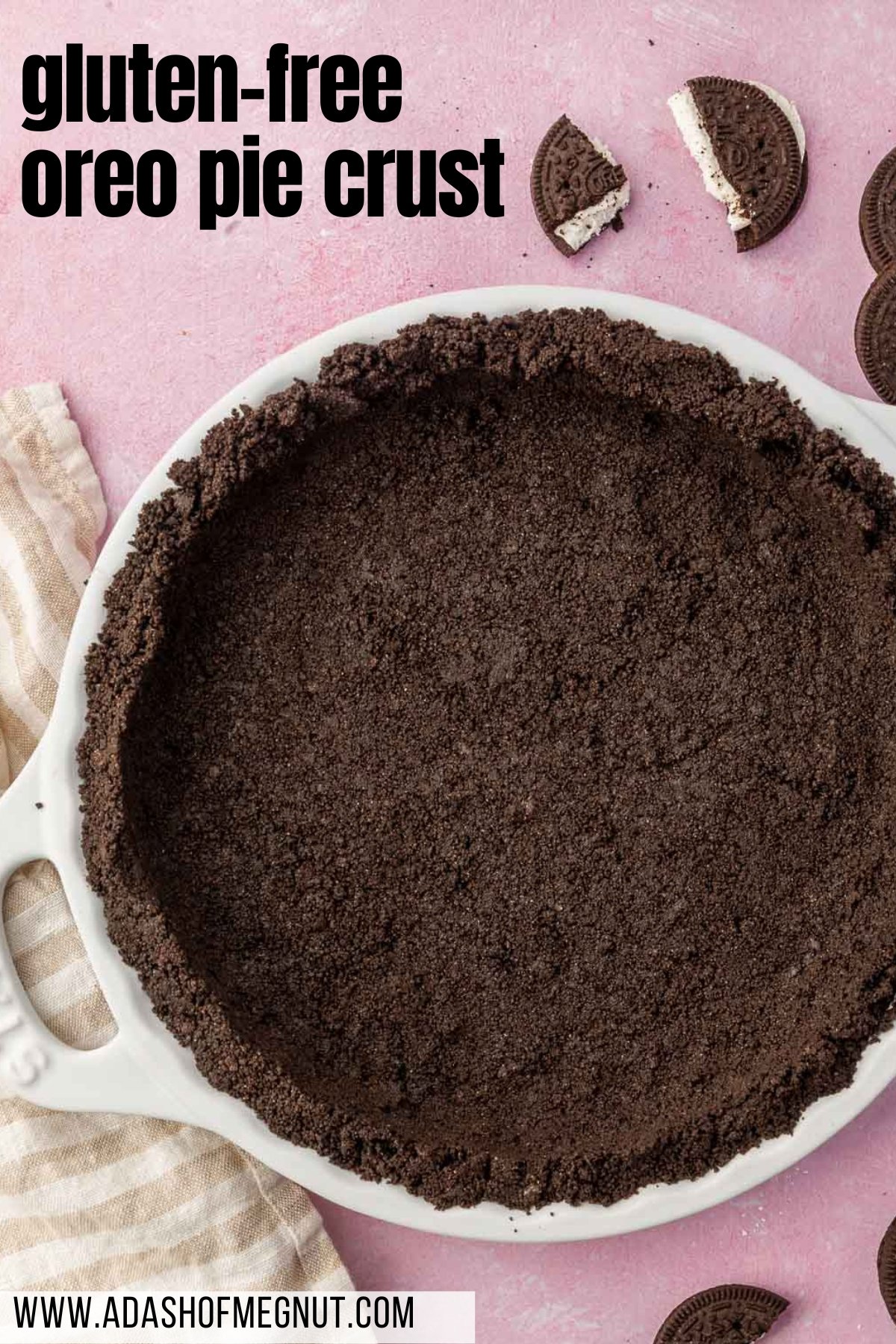 A close up of a gluten-free Oreo pie crust pressed into a white tart pan with broken Oreos surrounding the pan.