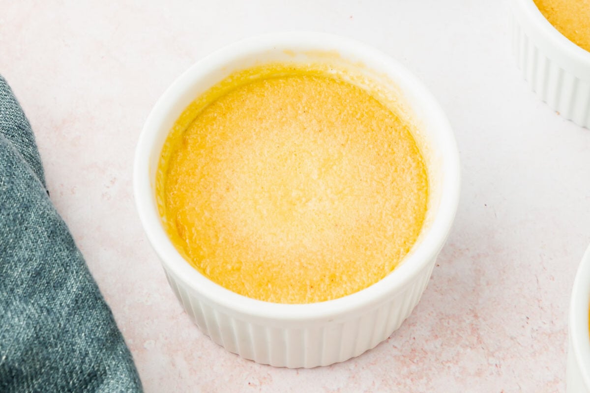 Three ramekins filled with baked pumpkin crème brûlée.