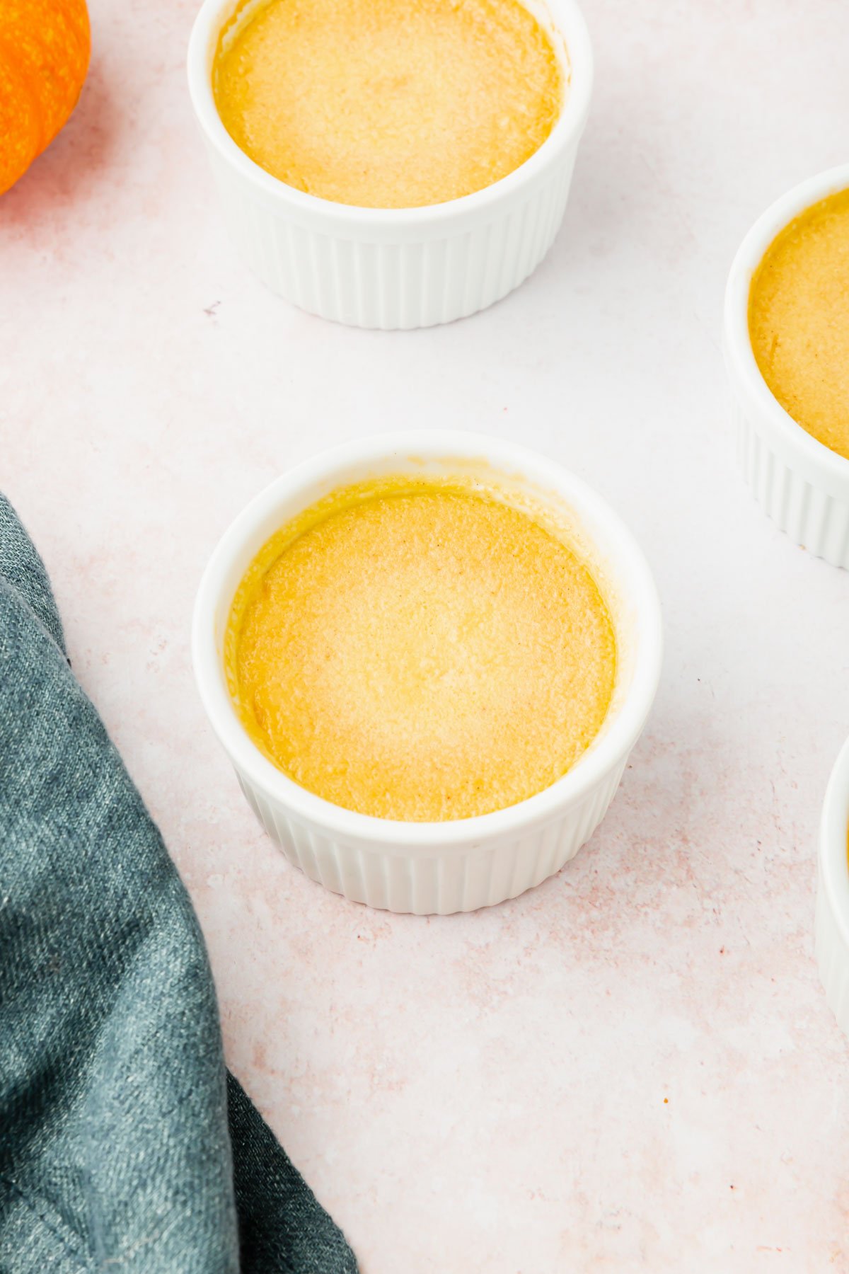 Three ramekins filled with baked pumpkin crème brûlée.