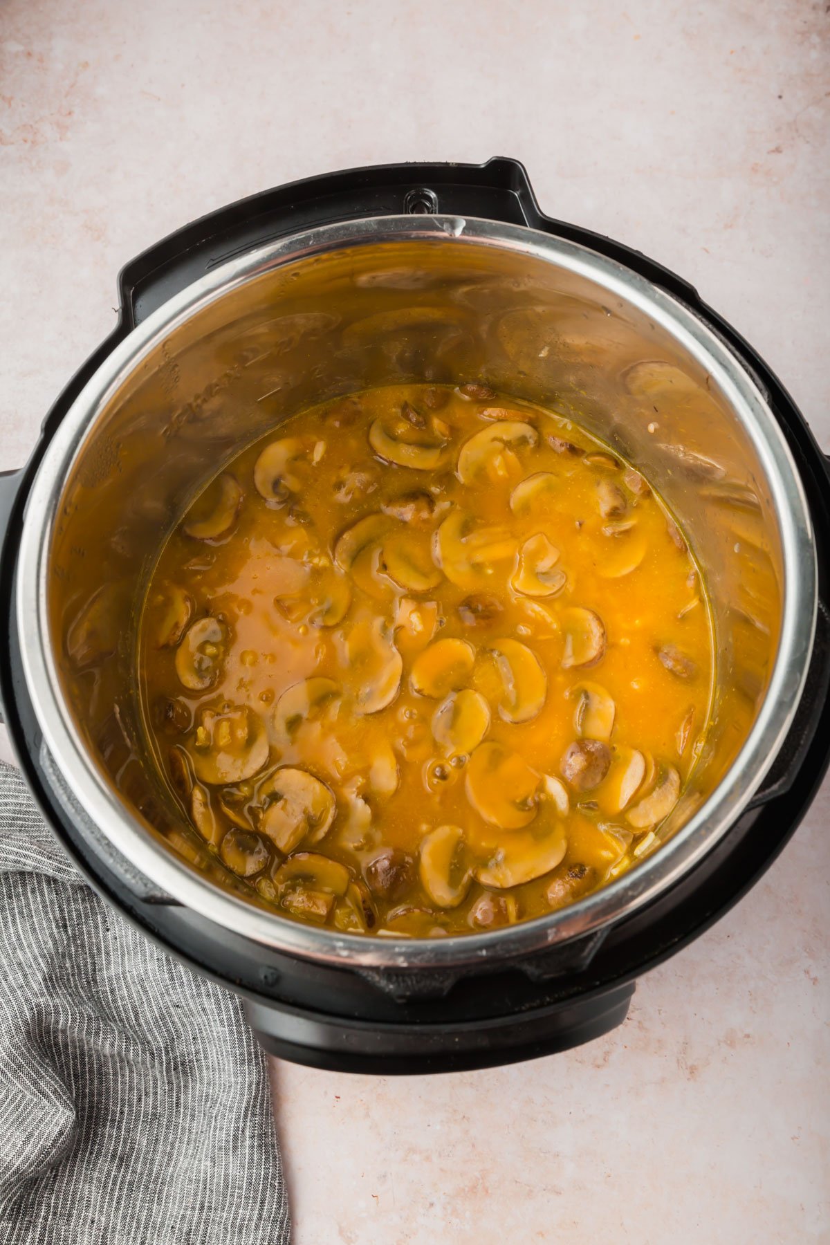 An Instant Pot filled with mushrooms in a mushroom broth.