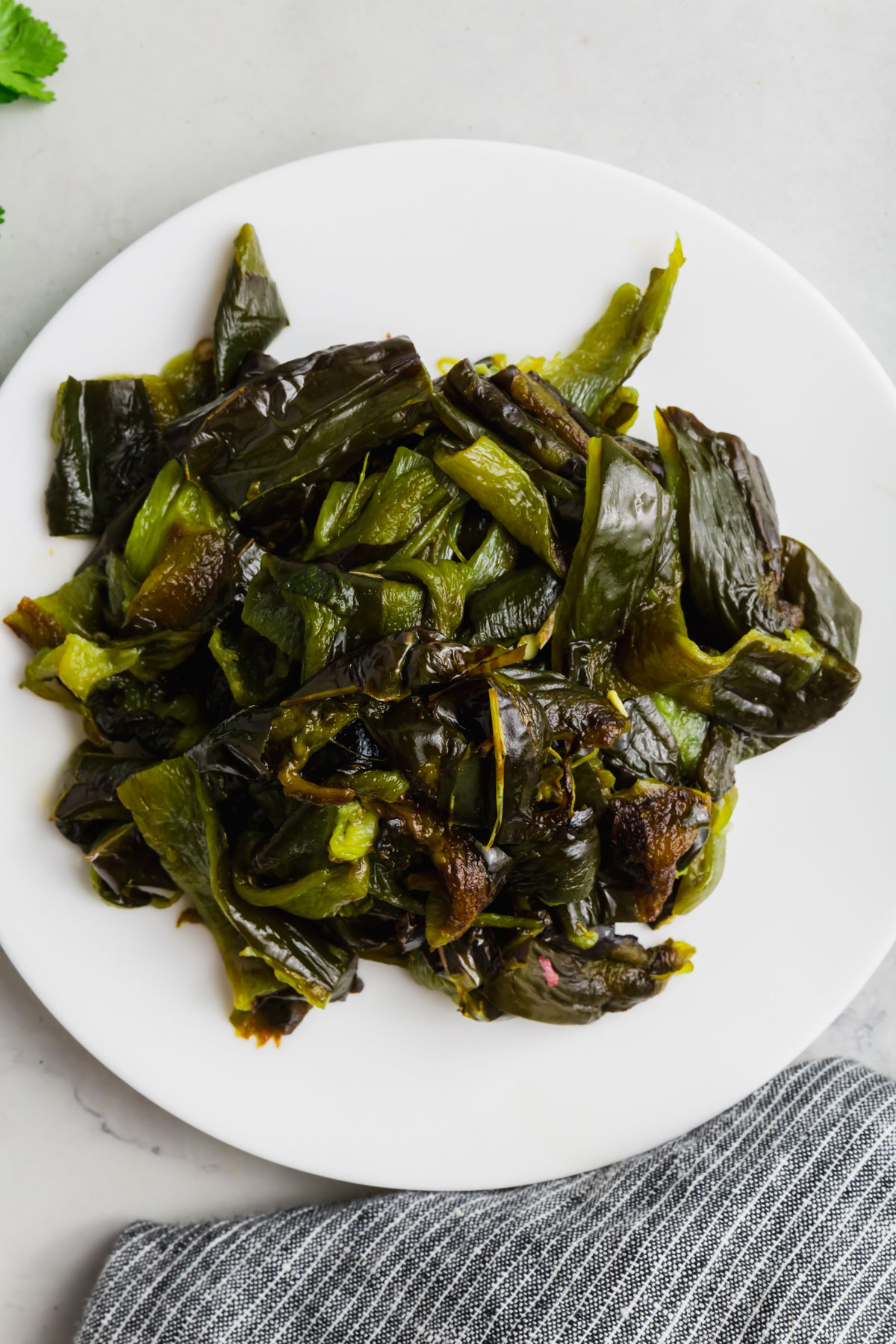 A plate of roughly chopped roasted poblano peppers.