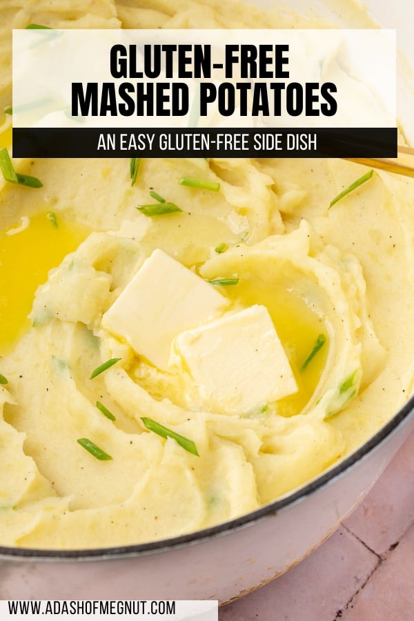 A close up of gluten-free mashed potatoes in a dutch oven with pats of melted butter and fresh chives with a gold serving spoon.