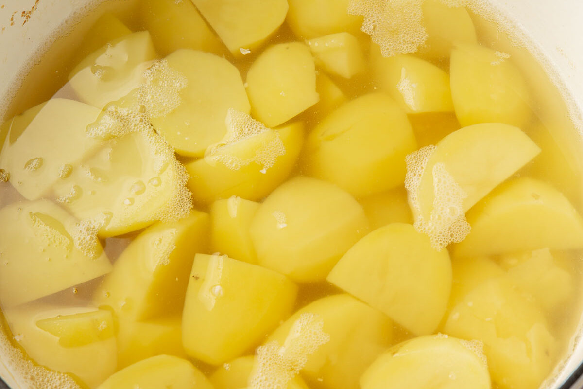 A dutch oven with potatoes that have been boiled in water.
