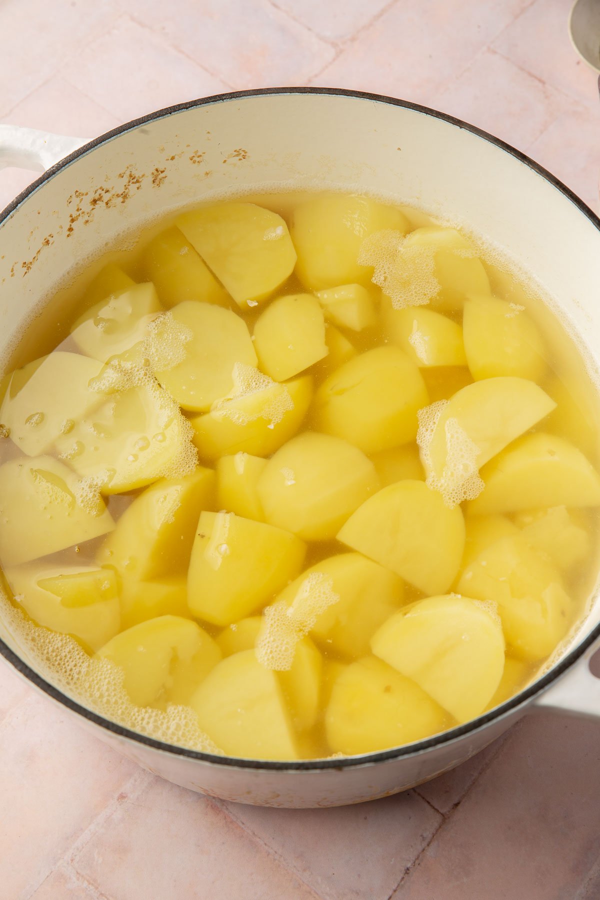 A dutch oven with potatoes that have been boiled in water.