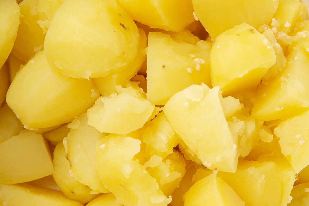 A dutch oven with boiled potato quarters.