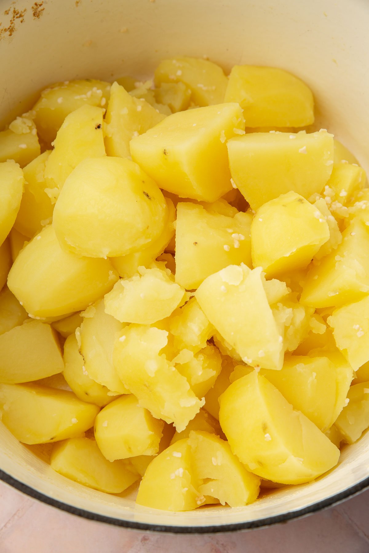 A dutch oven with boiled potato quarters.