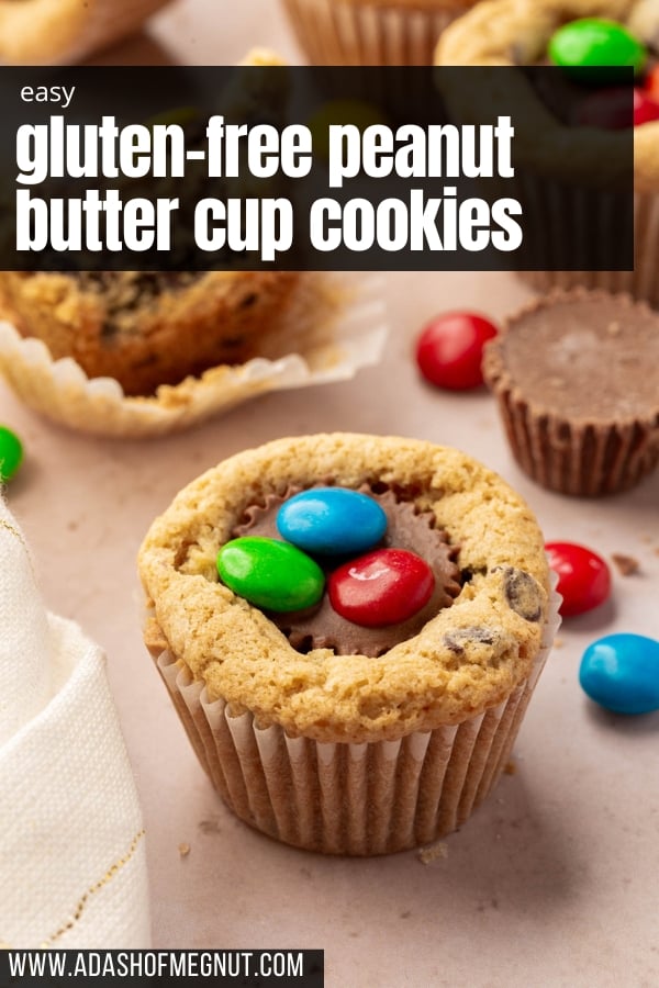 Chocolate chip cookie cup with a mini peanut butter cup inserted into the center and topped with three M&Ms.