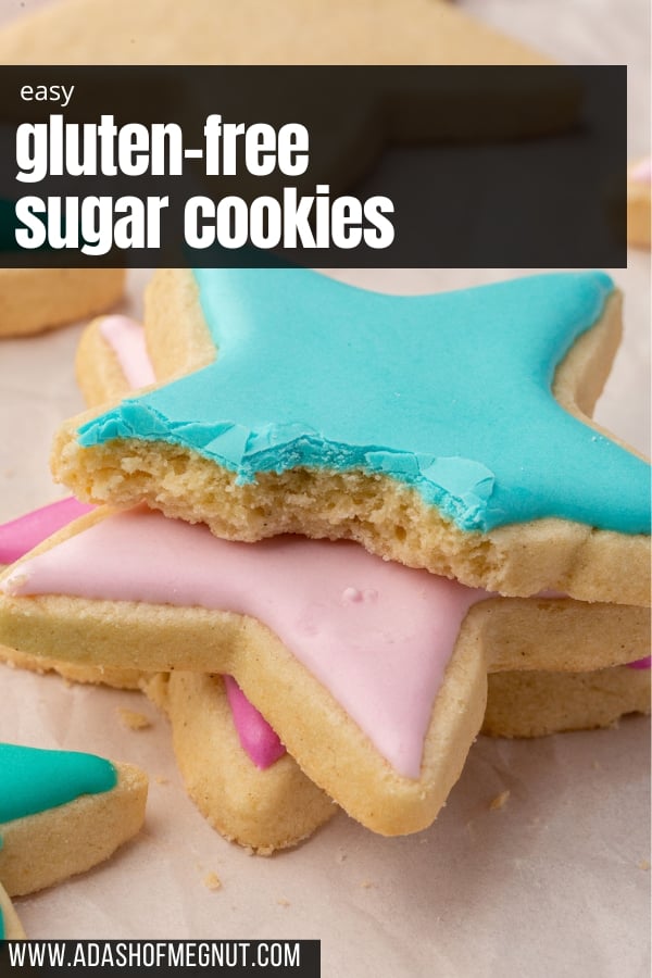Three decorated gluten free sugar cookies stacked on top of each other with blue, light pink and fuchsia royal icing.