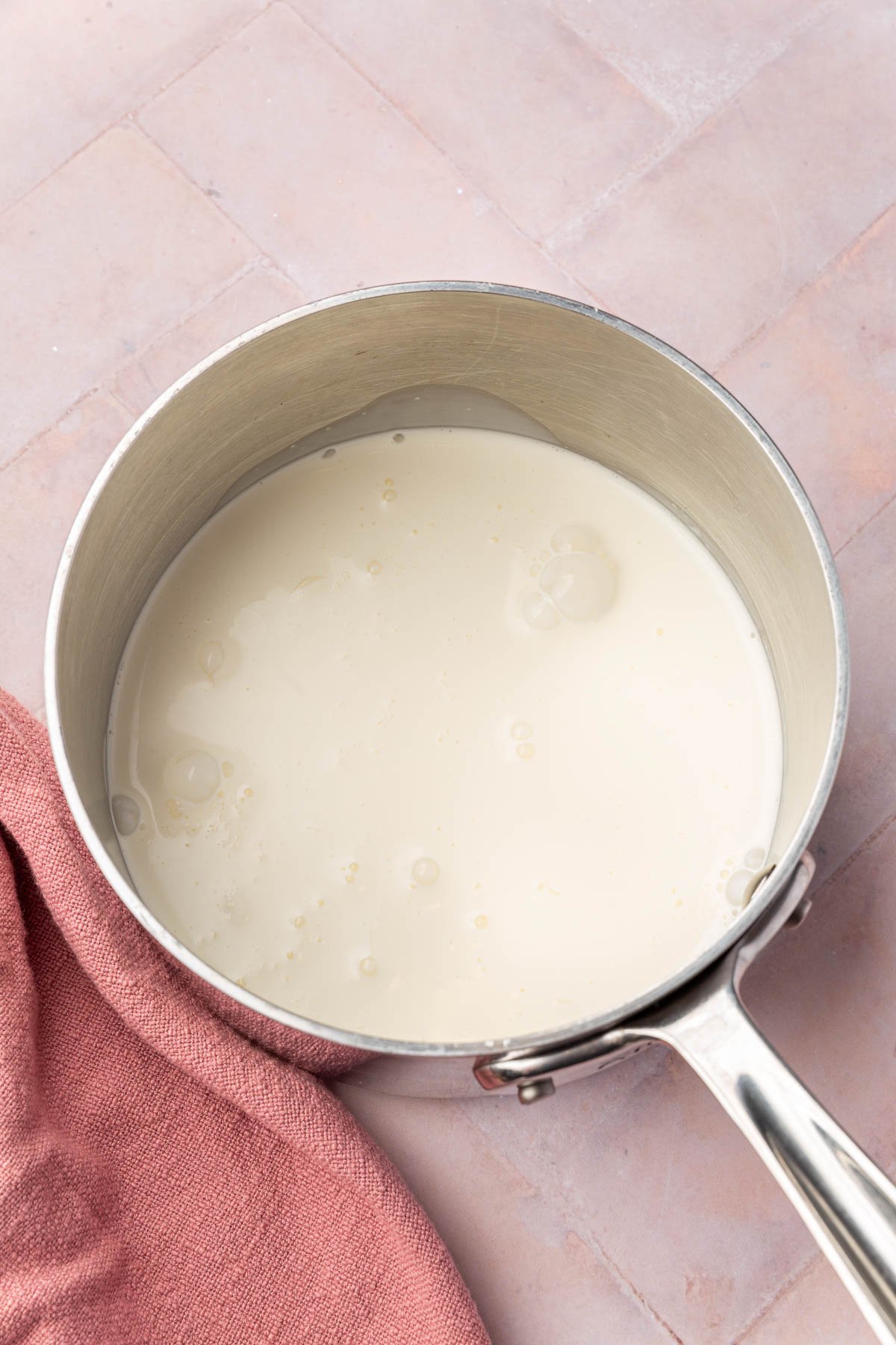 A saucepan with heavy cream in it.