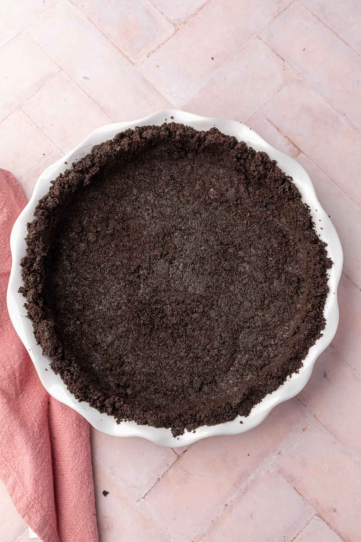A pie plate with gluten-free Oreo pie crust in it after baking in the oven.