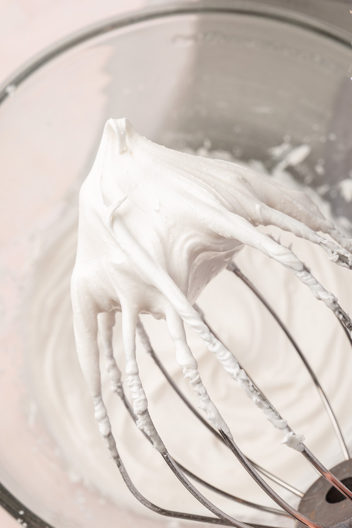 A whisk covered in white royal icing with a medium stiff peak.
