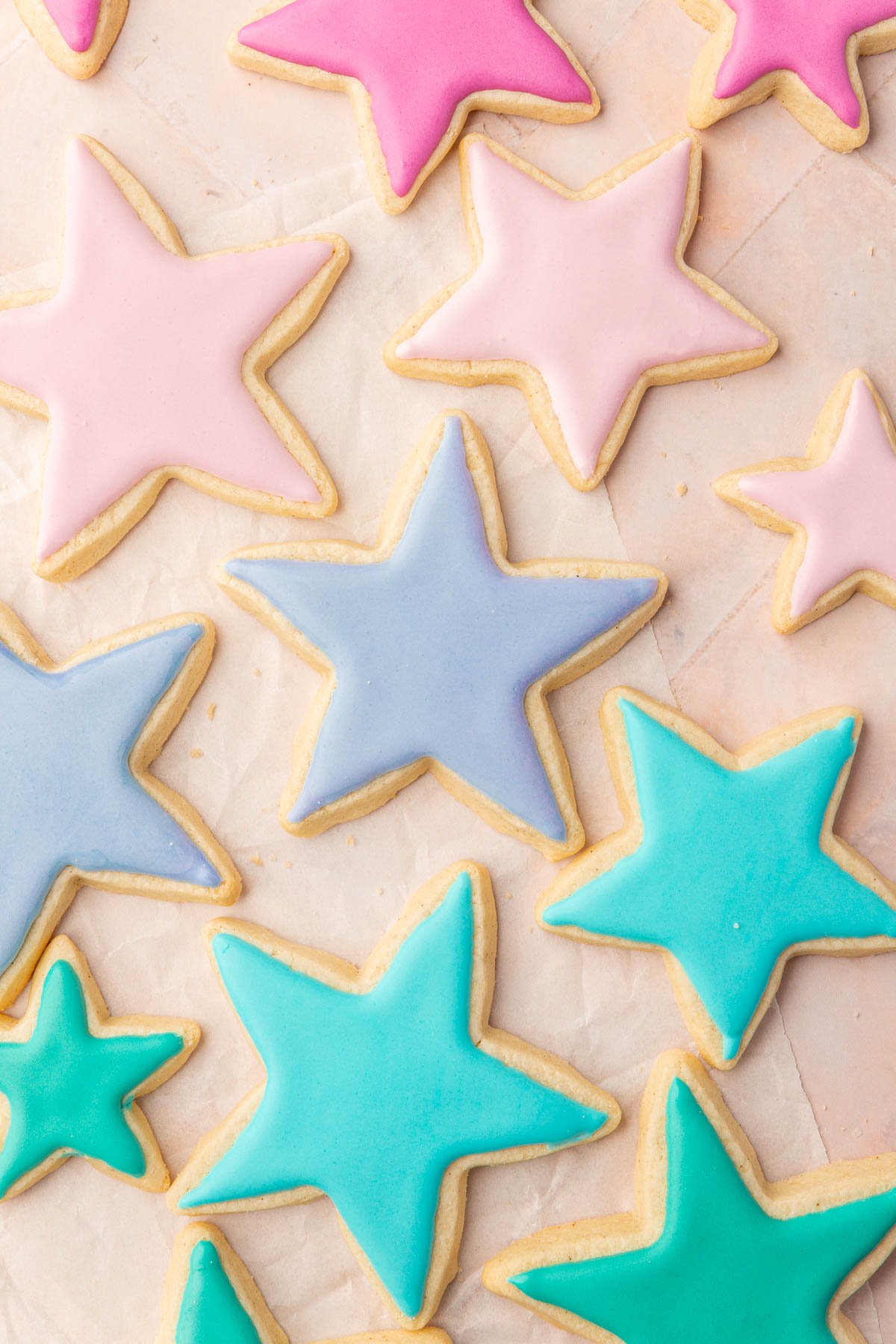 Star sugar cookies frosted with pink, purple, blue and green royal icing that has dried.