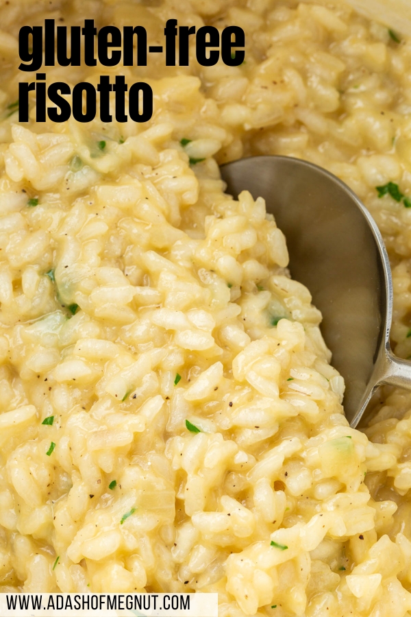 A close up of gluten free risotto with parmesan, black pepper and parsley with a large serving spoon.