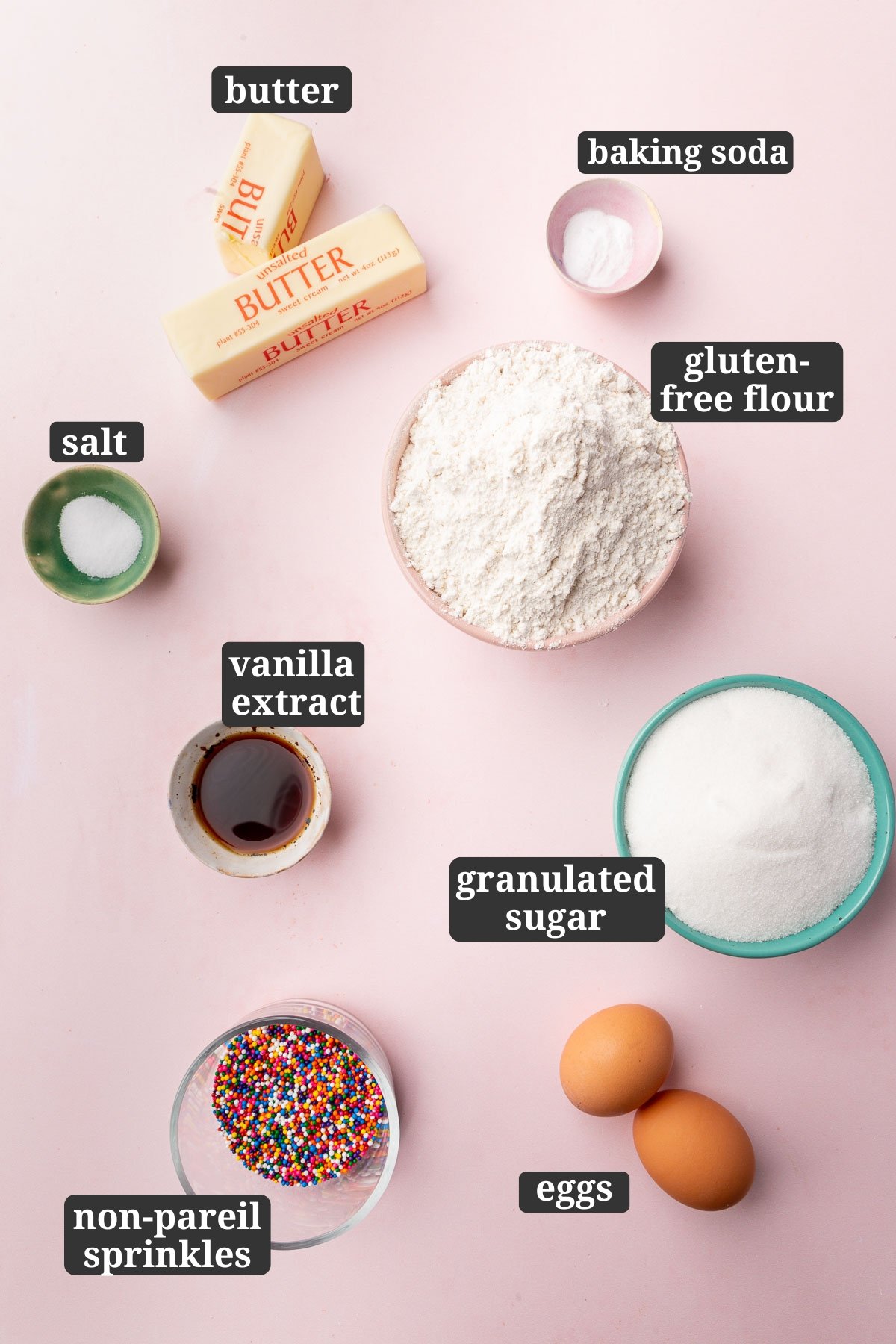 Ingredients in small bowls to make gluten-free sprinkles sugar cookies, including butter, baking soda, salt, gluten-free flour, vanilla, sugar, non-pareil sprinkles and eggs with text overlays over each ingredient.