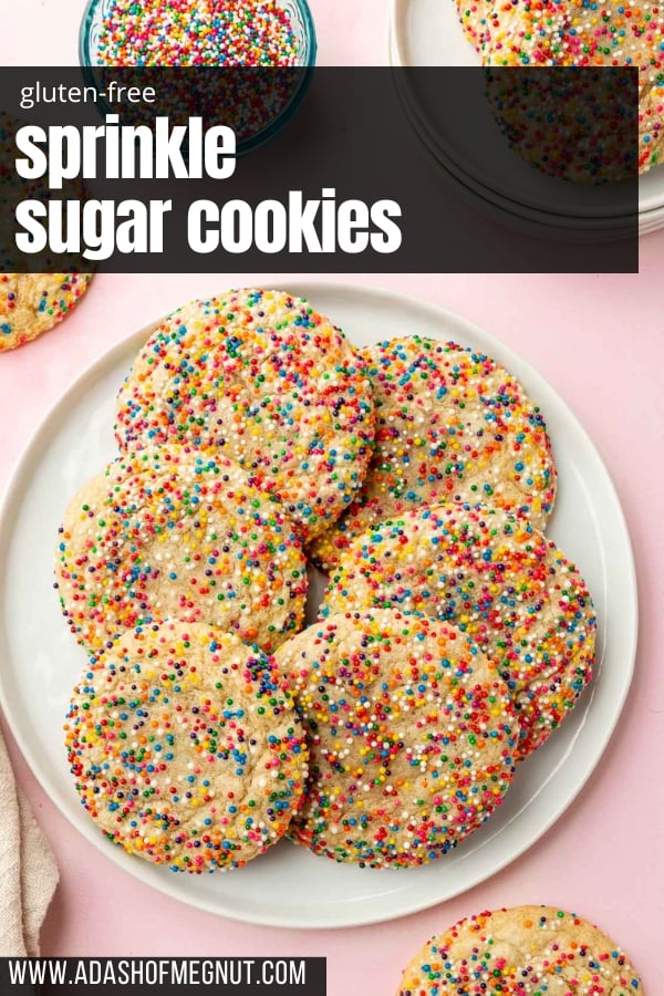 An overhead view of gluten free sprinkles sugar cookies on a plate on a pink table.