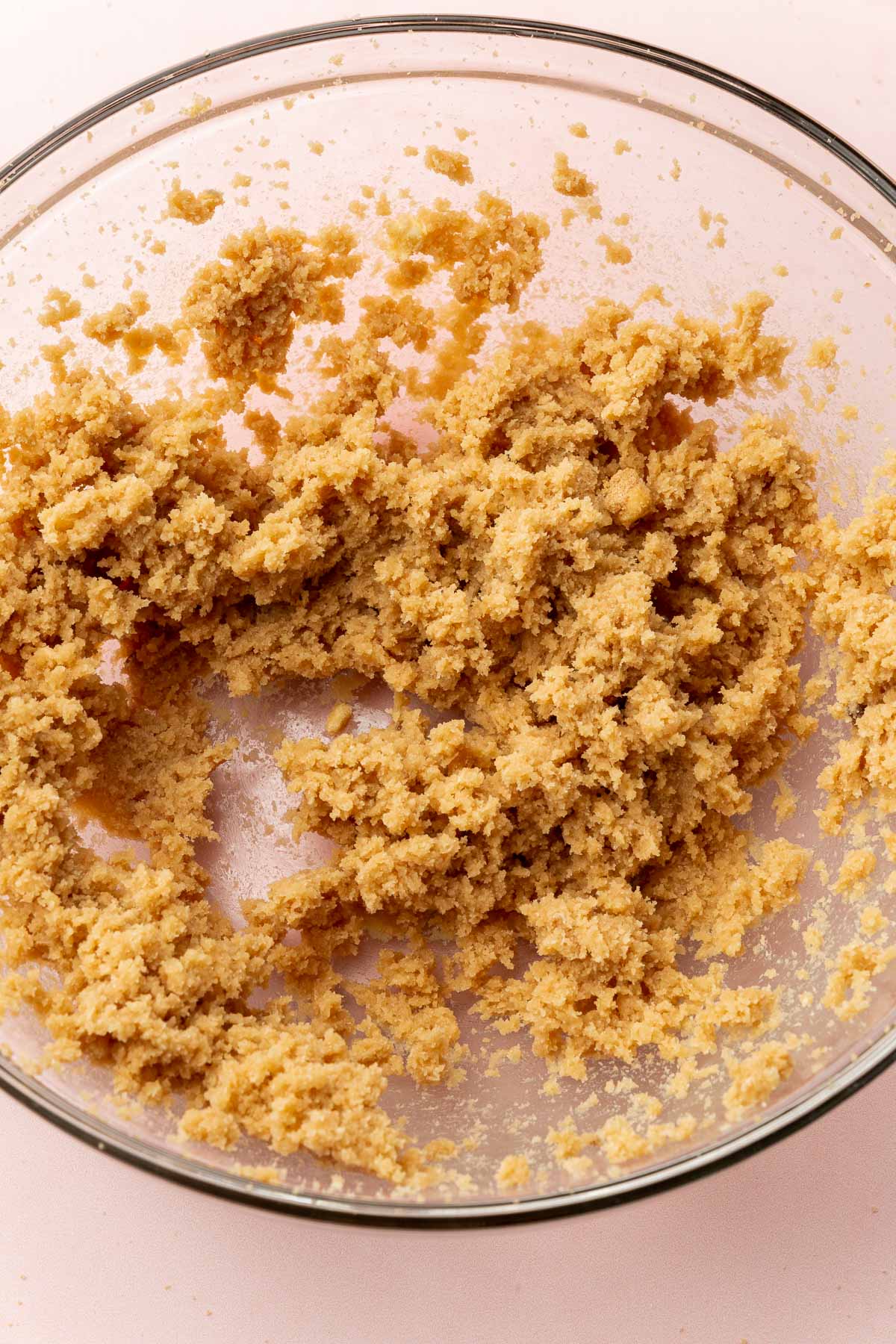A glass mixing bowl with butter, brown sugar and granulated sugar that has been creamed together.