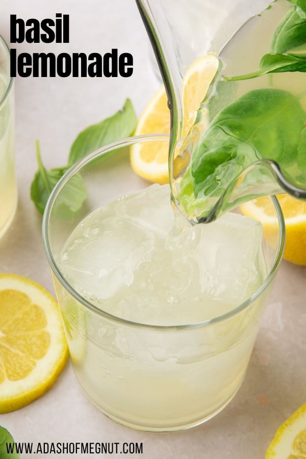 A pitcher pouring basil lemonade into a glass filled with ice.