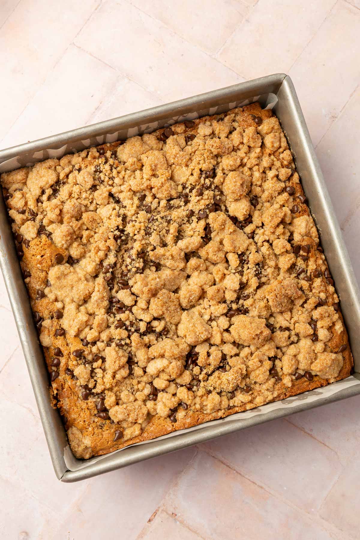 An overhead view of a square baking pan filled with glute-free chocolate c chip coffee cake with a gluten-free streusel.