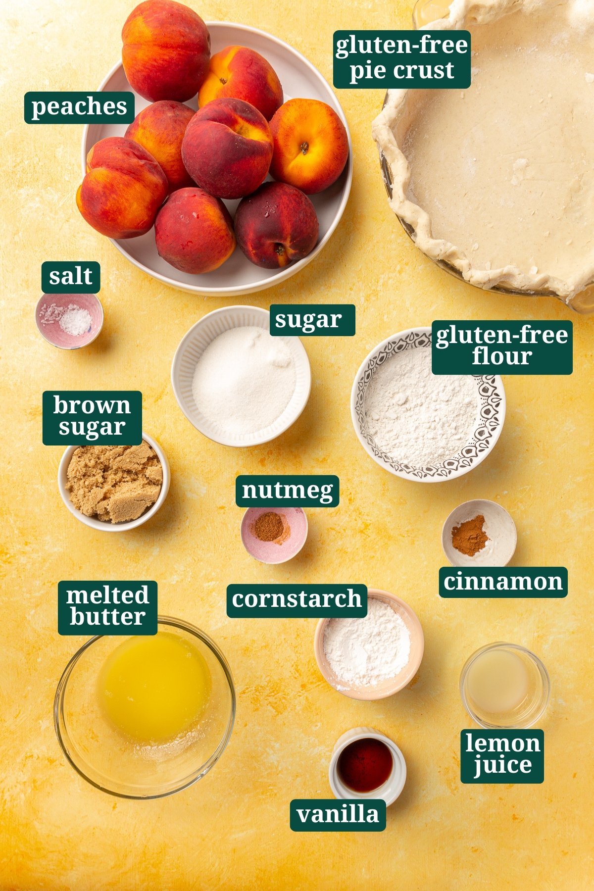 Overhead view of labeled ingredients for a gluten-free peach crumble pie, including peaches, sugar, brown sugar, flour, cinnamon, and nutmeg