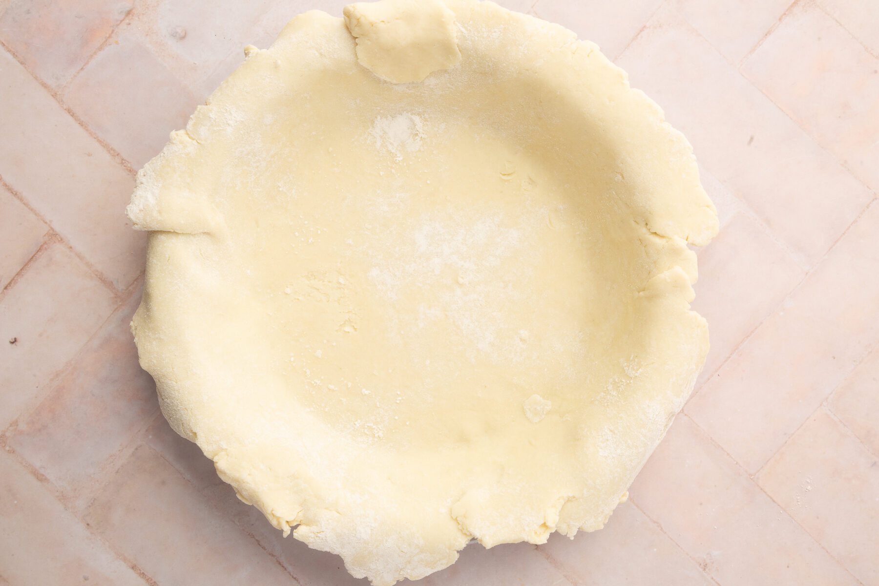 A raw, gluten-free pie crust placed in a pie dish, ready to be filled with the blueberry mixture.