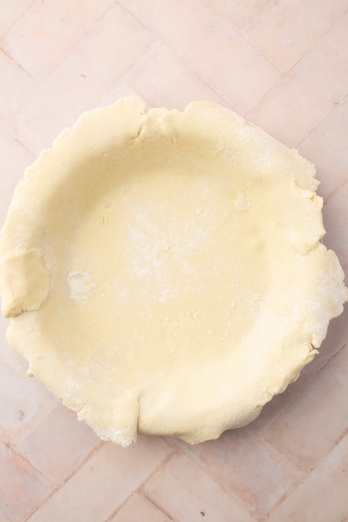 A raw, gluten-free pie crust placed in a pie dish, ready to be filled with the blueberry mixture.